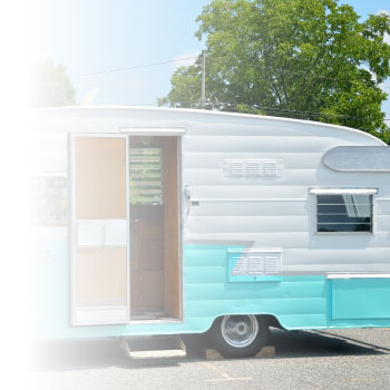 Green and White Camper in a Parking Lot